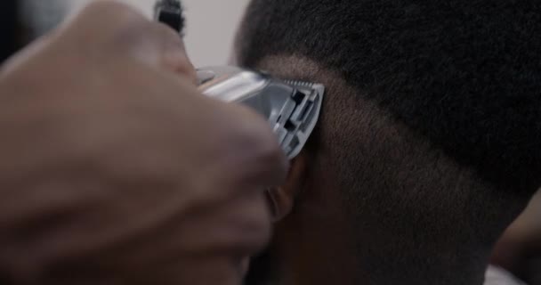 理髪店で頭から髪を削除シェービングマシンと手のクローズアップ サロンコンセプトの電気機器と現代技術 — ストック動画