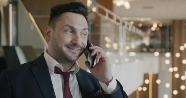 穿着西装的成功商人形象在豪华酒店大堂用手机交谈 微笑着分享好消息 人与通信概念 — 图库视频影像