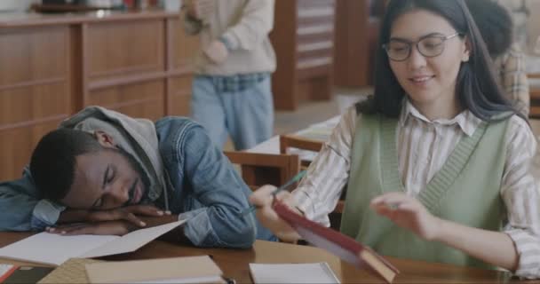 Ázsiai Főiskolai Könyvtárban Tanul Miközben Fáradt Afro Amerikai Férfi Lusta — Stock videók