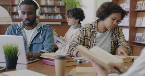 Diverso Grupo Estudiantes Que Realizan Tareas Biblioteca Leyendo Libros Utilizando — Vídeo de stock
