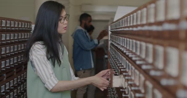 Разнообразная Группа Студентов Ищущих Книги Университетском Каталоге Библиотек Поисках Информации — стоковое видео