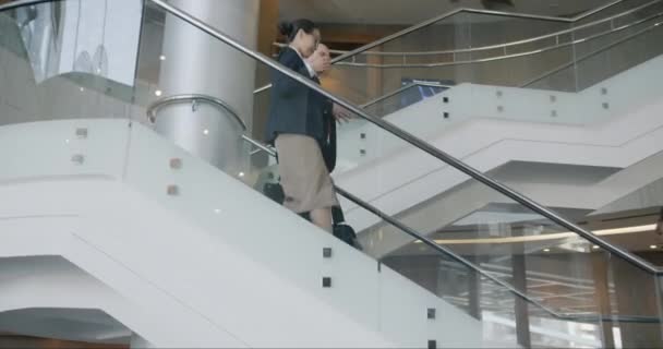 穿着雅致的正装的男男女女走下楼梯 在现代化的商务舱酒店里交谈 人与企业生活方式概念 — 图库视频影像