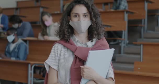 講堂に立ち並ぶフェイスマスクをした女子高生の肖像画 Covid 19パンデミックと教育の概念 — ストック動画