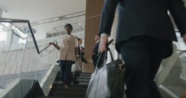 Modern lüks otellerde üst katta yürüyen şık iş adamları selamlıyor ve gülümsüyor. Konaklama ve girişimci konsepti.
