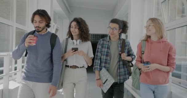 男生和女生在校园边散步边喝咖啡边用智能手机的慢动作 年轻人的生活方式和大学教育观念 — 图库视频影像