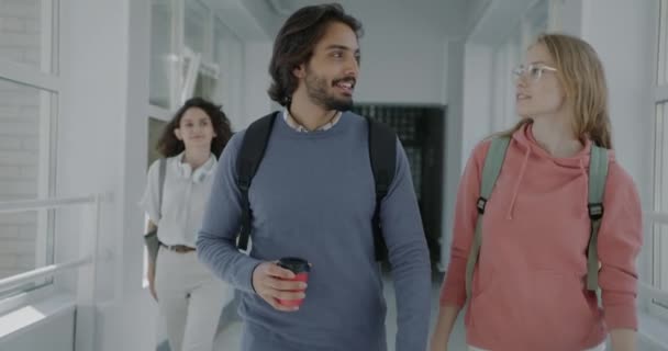 幸せなアラブ人男性と白人女性のスローモーションポートレート高校でコーヒーを飲みに話を歩く 教育と人々の概念 — ストック動画