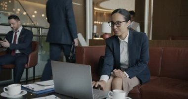Çift ırklı iş kadını otel odasında dizüstü bilgisayar kullanıyor. Modern teknoloji ve girişimciler konsepti.