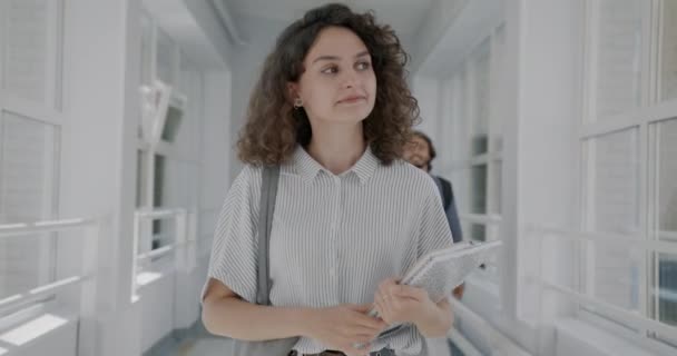 Dolly Sköt Vackra Unga Kvinna Promenader Universitetshallen Med Böcker Viftande — Stockvideo
