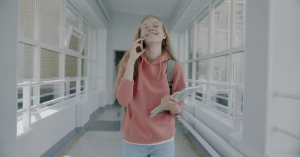 Tasasız Genç Bir Kadının Lise Koridorunda Yürürken Cep Telefonuyla Sohbet — Stok video