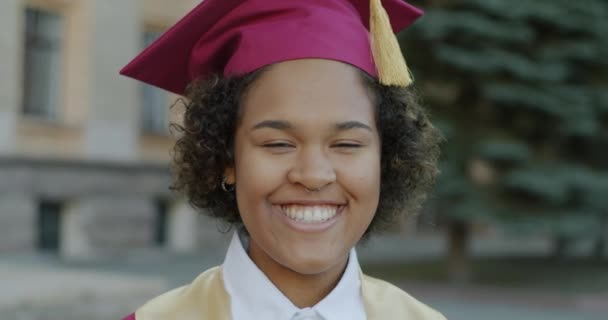 Närbild Porträtt Stolt Afroamerikansk Dam Bär Examen Hatt Ler Utomhus — Stockvideo