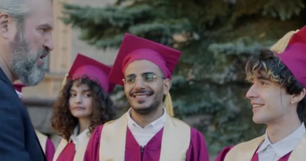 Orgulhoso Pai Parabenizando Jovem Estudante Vestindo Chapéu Formatura Vestido Abraçando — Vídeo de Stock