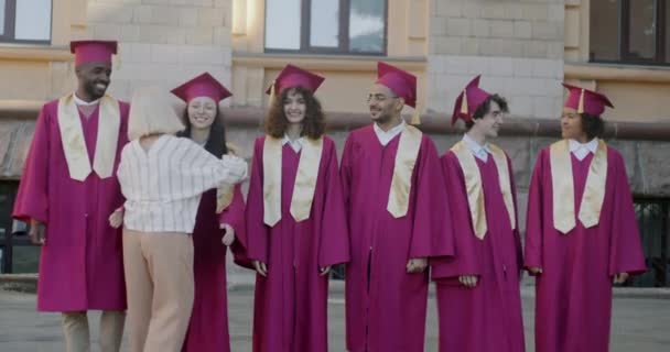 大学教授们拥抱着一群戴着毕业帽的年轻人 恭贺他们成功完成学业 学生们拥抱老师的快乐 — 图库视频影像