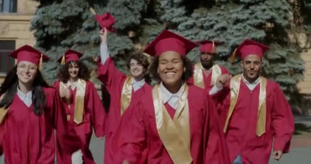 Zeitlupenaufnahmen Aufgeregter Studenten Abschlussmützen Und Kleidern Die Auf Dem Campus — Stockvideo