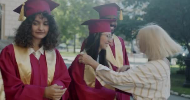 Зрелая Женщина Профессор Колледжа Обнимает Аспирантов Поздравляя Дипломом Кампусе Концепция — стоковое видео