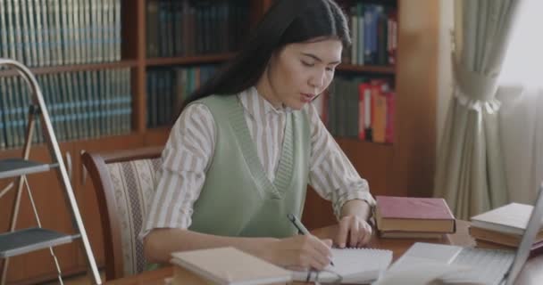 Усердная Студентка Азиатка Учится Одна Библиотеке Помощью Ноутбука Пишет Блокноте — стоковое видео