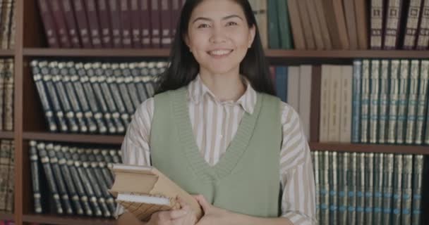Portret Przyjaznej Azjatki Bibliotekarki Stojącej Bibliotece Uśmiechniętej Półkami Tle Koncepcja — Wideo stockowe