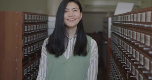 Kütüphanede Durup Bilgiye Ulaşmanın Keyfini Çıkarırken Gülümseyen Asyalı Genç Bir — Stok video