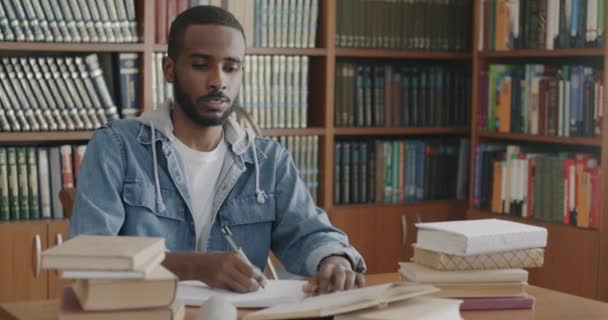 Joven Estudiante Concentró Leer Escritura Libros Cuaderno Biblioteca Con Estantes — Vídeo de stock