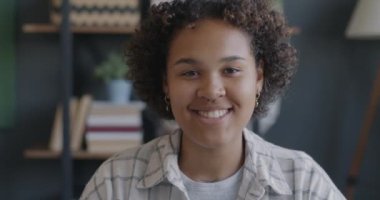 Slow motion portrait of joyful office worker African American woman smiling looking at camera in workplace. Positive emotion and job concept.