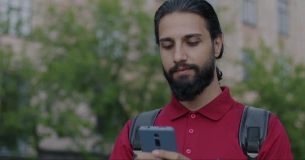 Slow Motion Portrait Carefree Middle Eastern Man Backpack Browsing Smartphone — Stok video