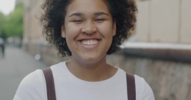 Şehirli caddelerde eğlenen Afrikalı Amerikalı kadının ağır çekimde çekilmiş bir portresi. Mutluluk ve neşeli gençlik konsepti.