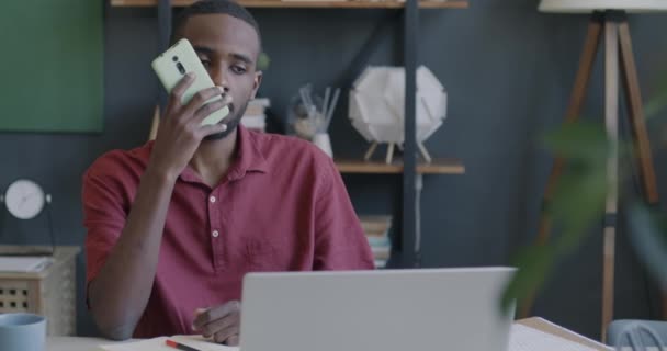 Afroamerikansk Affärsman Spela Och Lyssna Ljudmeddelanden Med Smartphone Tittar Bärbar — Stockvideo