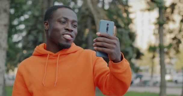 幸せなアフリカ系アメリカ人の学生の肖像画 オンラインビデオ通話チャットや街の外で手を振る 人とコミュニケーションの概念 — ストック動画