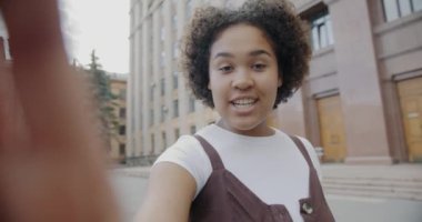 Dost canlısı Afrikalı Amerikalı öğrencinin portresi üniversiteyi ve açık havada konuşmayı gösteren çevrimiçi video görüşmesi yapıyor. İnsanlar ve iletişim konsepti.