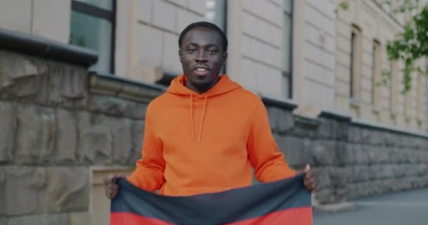 Медленный Портрет Патриота Афроамериканца Размахивающего Немецким Национальным Флагом Улыбающегося Улице — стоковое видео