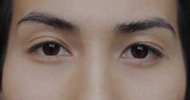 Güzel Asyalı kadın gözlerinin kameraya bakarken yanıp sönen görüntüsü. Görme yeteneği ve çekici genç bayan konsepti.