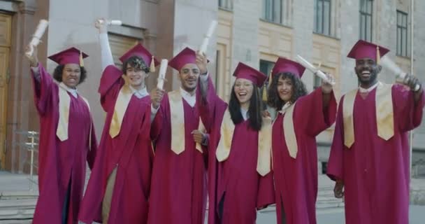 Retrato Pessoas Graduados Universitários Acenando Diplomas Ensino Superior Rindo Campus — Vídeo de Stock