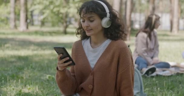Веселая Молодая Женщина Пользующаяся Смартфоном Слушающая Музыку Наушниками Парке Летний — стоковое видео