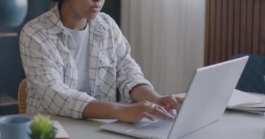 Başarılı bir Afrikalı Amerikalı kadın dizüstü bilgisayarla çalışıyor. Evde çalışmaya odaklanmış. Halk ve serbest meslek kavramı.