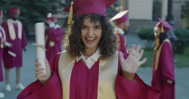 Retrato Jovem Excitada Boné Formatura Roupão Expressando Felicidade Segurando Diploma — Vídeo de Stock