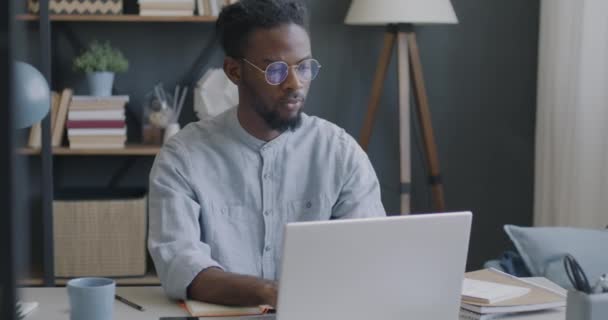 Мотивированный Молодой Человек Работающий Ноутбуком Дома Выражает Удовлетворение Наслаждаясь Внештатной — стоковое видео
