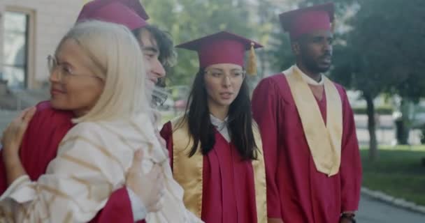 Glücklicher Dekan Gratuliert Multiethnischen Studentengruppen Beim Händeschütteln Und Umarmt Junge — Stockvideo