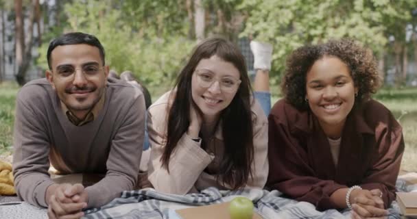 Amigos Multiétnicos Estudiantes Hombre Mujer Tumbados Césped Parque Sonriendo Mirando — Vídeos de Stock