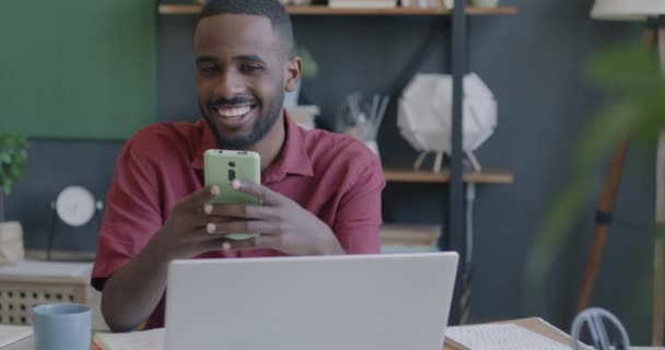 Empresário Afro Americano Alegre Olhando Para Tela Smartphone Sorrindo Sentado — Vídeo de Stock