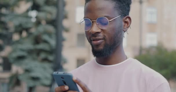 Genç Afro Amerikan Öğrenci Akıllı Telefon Kullanarak Sosyal Medyayı Kontrol — Stok video