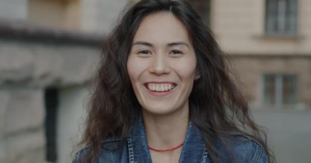 兴高采烈的亚洲女人慢吞吞地笑了起来 高兴而兴奋地站在城市街道上 人与积极情绪概念 — 图库视频影像