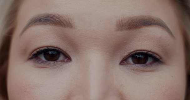 在模糊的室外背景下 年轻的亚洲女人的近视眼睛看着相机 人的情感和面部表情概念 — 图库视频影像