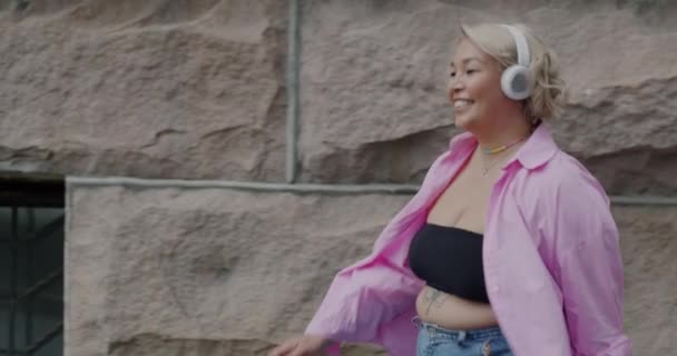 Joyful Young Lady Wearing Headphones Listening Music Walking City Dancing — Stock Video