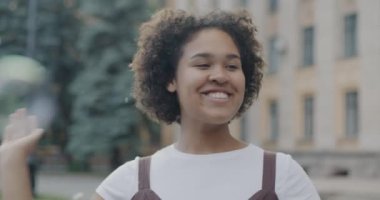 Kaygısız Afro-Amerikan kadın portresi havada uçuşan sabun köpükleriyle eğleniyor ve şehirde gülüyor. İnsanlar ve yaz neşesi kavramı.