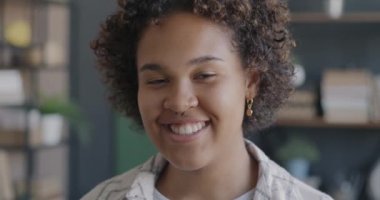 Evdeki mutluluğu ifade eden gülümseyen Afro-Amerikan genç bayanın yakın plan portresi. İnsanlar ve olumlu duygu kavramı.