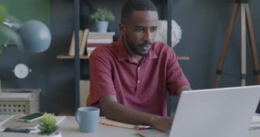 Bilgisayarla çalışan mutlu Afro-Amerikan adam ofiste başarıyı kutlayan iyi haberler alıyor. Başarılı insanlar ve heyecan ifadesi kavramı.