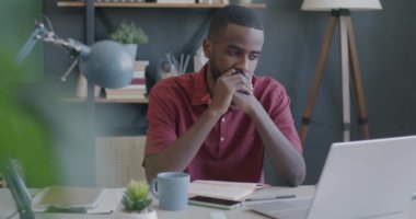 Ofisteki laptop ekranına bakarak düşünen dalgın Afrikalı Amerikalı girişimcinin portresi. İş meydan okuma ve çözüm kavramı.