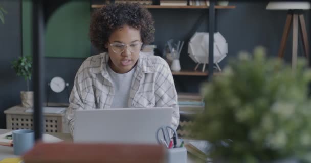 ストレスを受けたアフリカ系アメリカ人女性はラップトップで働き オフィスに座っているフラストレーションと怒りを表現しました 仕事とネガティブな感情のコンセプト — ストック動画