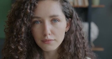 Kapalı mekanda kameraya bakan şık bir ofis çalışanının yavaş çekim portresi. İş ve başarılı insanlar konsepti.