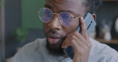 Ofiste cep telefonu görüşmeleri sırasında iş konuşan Afrikalı Amerikalı girişimcinin yakın çekimi. Cep telefonu konuşması ve iş konsepti.