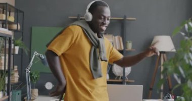 Evde eğlenen, kulaklıkla müzik dinleyen Afro-Amerikan 'ın ağır çekimleri. İnsanlar ve modern yaşam tarzı kavramı.